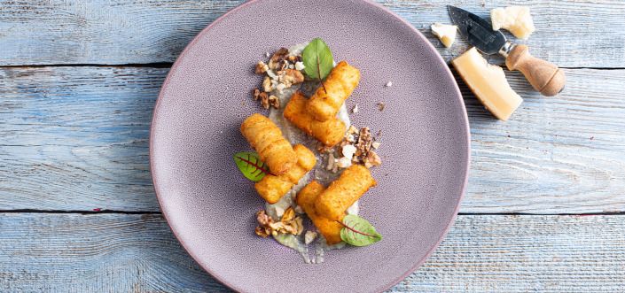 Картофельные крокеты, подаваемые с соусом из четырех сыров и жареными грецкими орехами